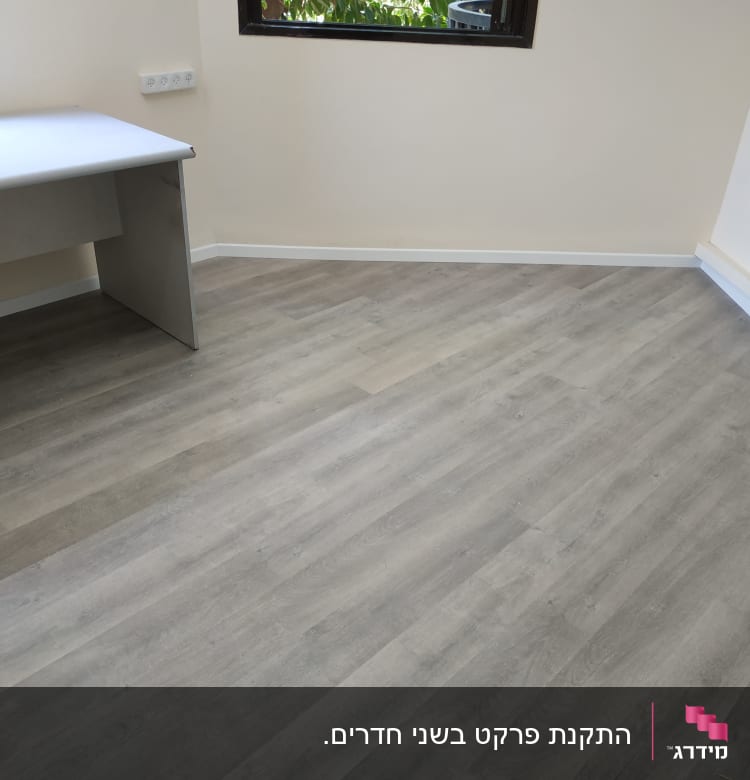רצפת פרקט עץ אפורה בחדר ריק עם שולחן